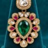 Close-up of one Mayur earring with square kundan-style top and emerald-toned teardrop