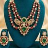 Mayur kundan three-strand necklace with emerald-toned peacock centrepiece and matching earrings on a teal velvet stand