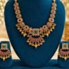 opulence-design10-1-600x900 Ruby-red temple necklace with crescent pendant and matching earrings on a teal stand