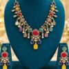 opulence-design2-main-600x900 Navratna-colour stone necklace with red oval centre, yellow drop and matching earrings on a teal stand