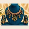 Emerald-green meena jhumka choker necklace and matching earrings on a teal velvet stand