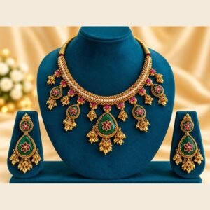 Emerald-green meena jhumka choker necklace and matching earrings on a teal velvet stand