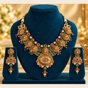 Antique floral medallion necklace with green bead strands and matching earrings on a navy stand